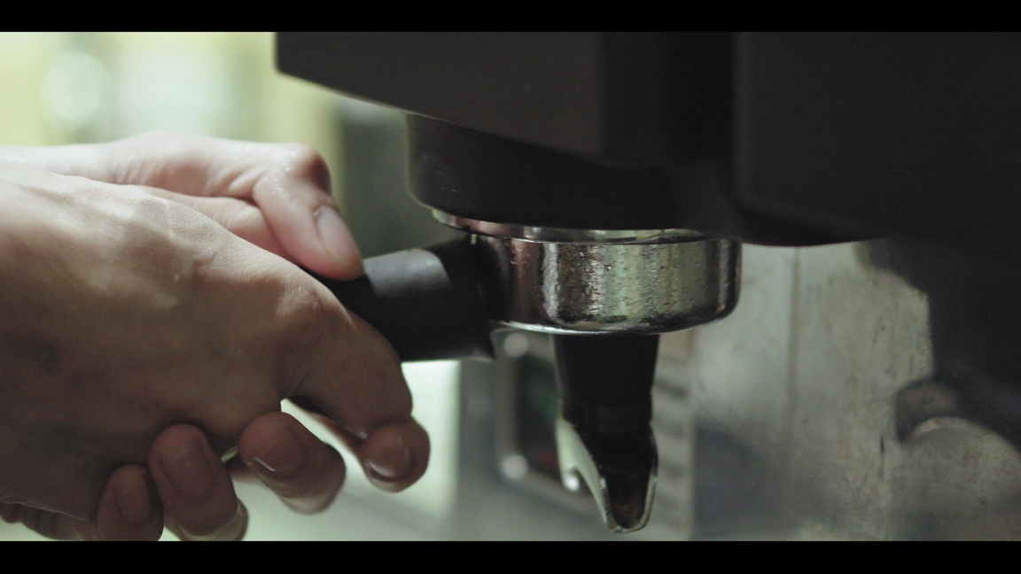 a close up of a hand holding a coffee machine