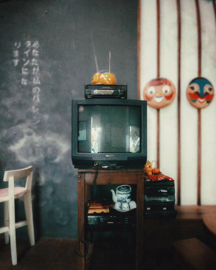an old television sitting on top of a table in front of a chalkboard