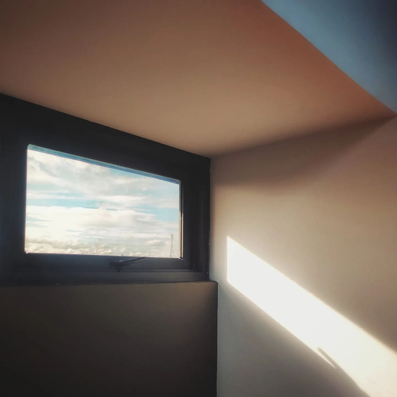 a view of the sky through a window in an empty room