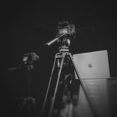 a black and white photo of a laptop on a tripod